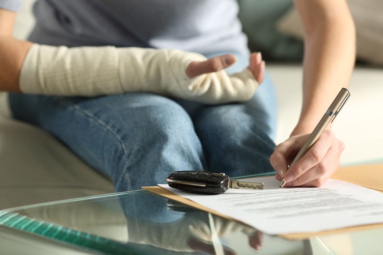 Lady with broken arm signing insurance document after car accident