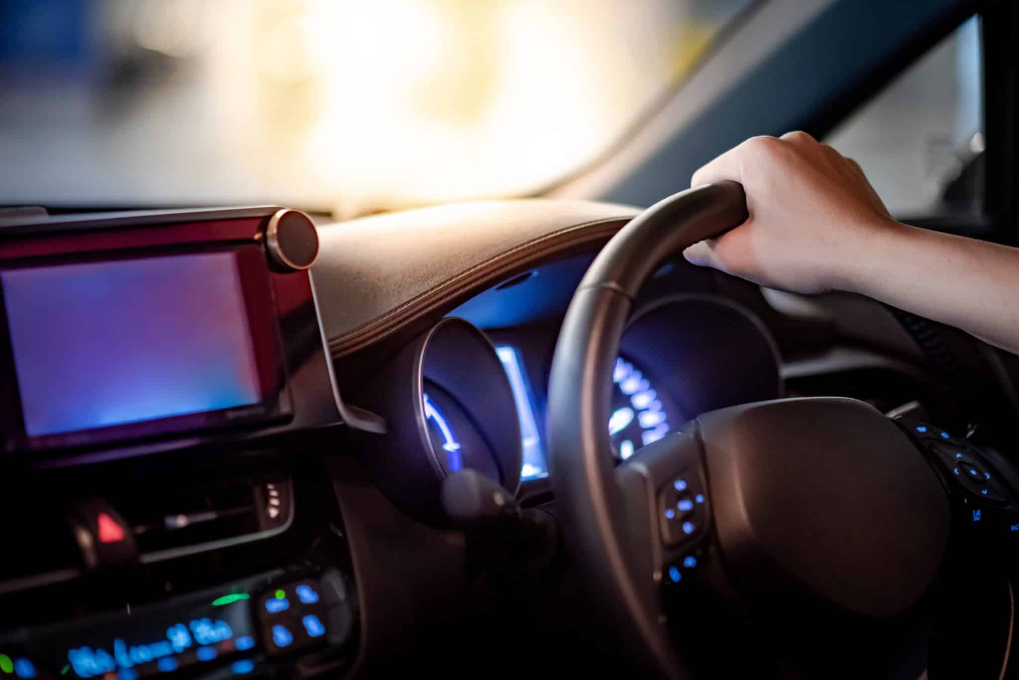 Driver hand holding steering wheel in the car