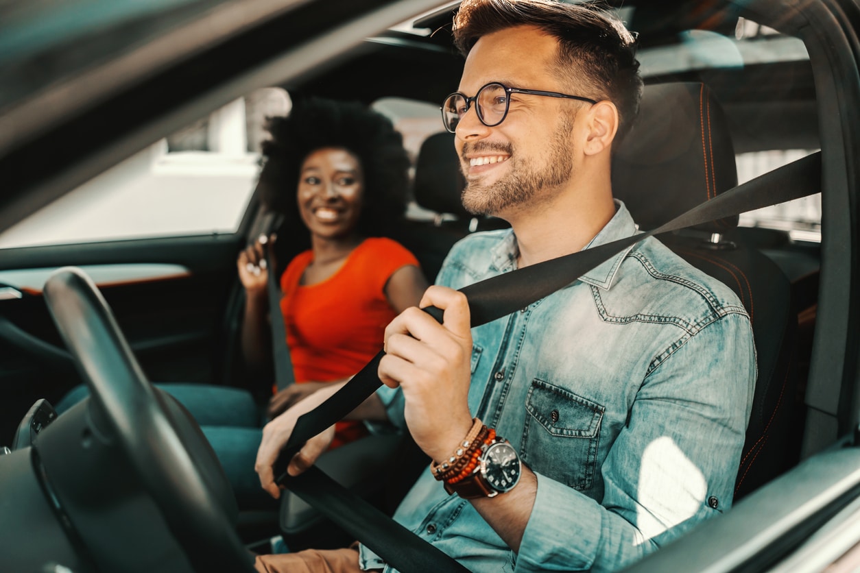 woman in red shirt letting someone else drive car